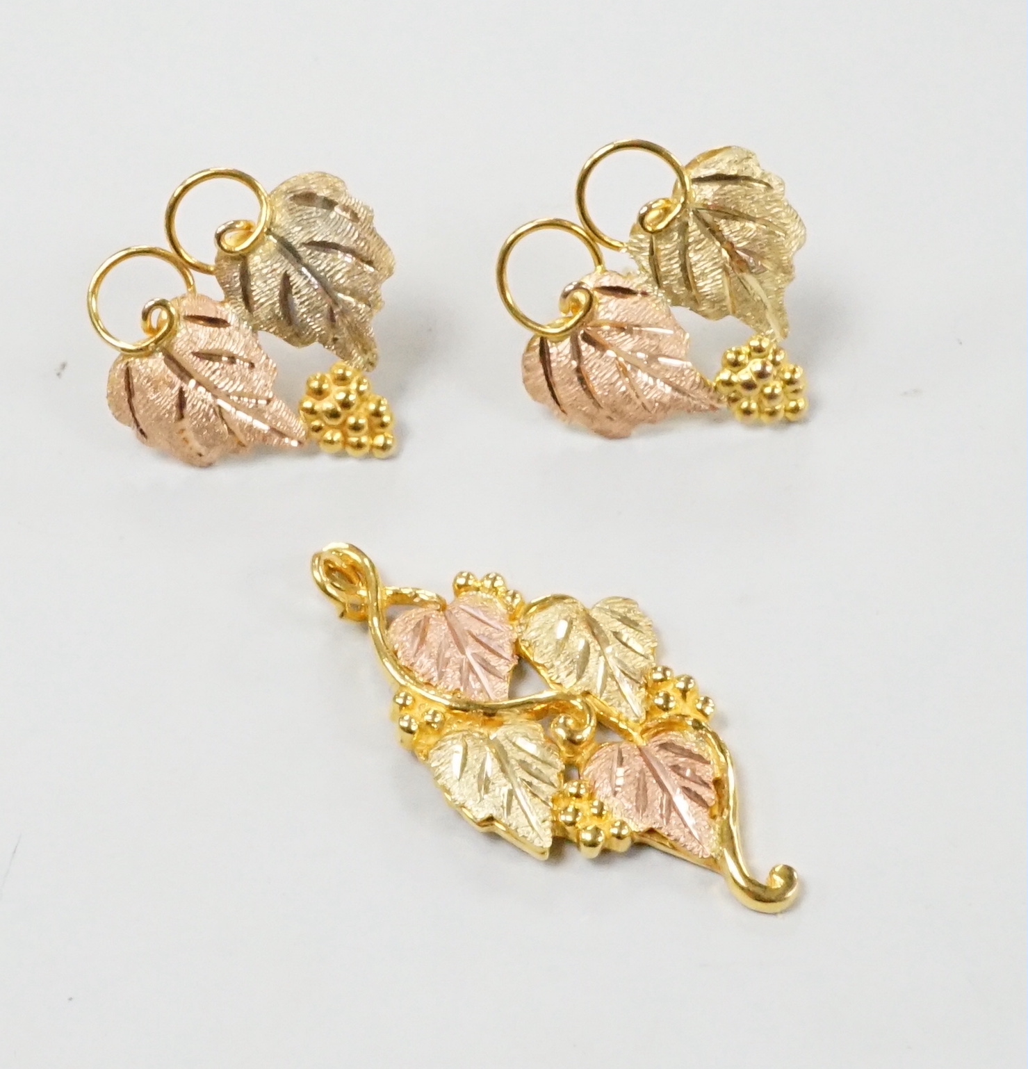 A modern three colour 10k leaf pendant, 31mm and a pair of matching earrings (no butterflies), 5.1 grams.